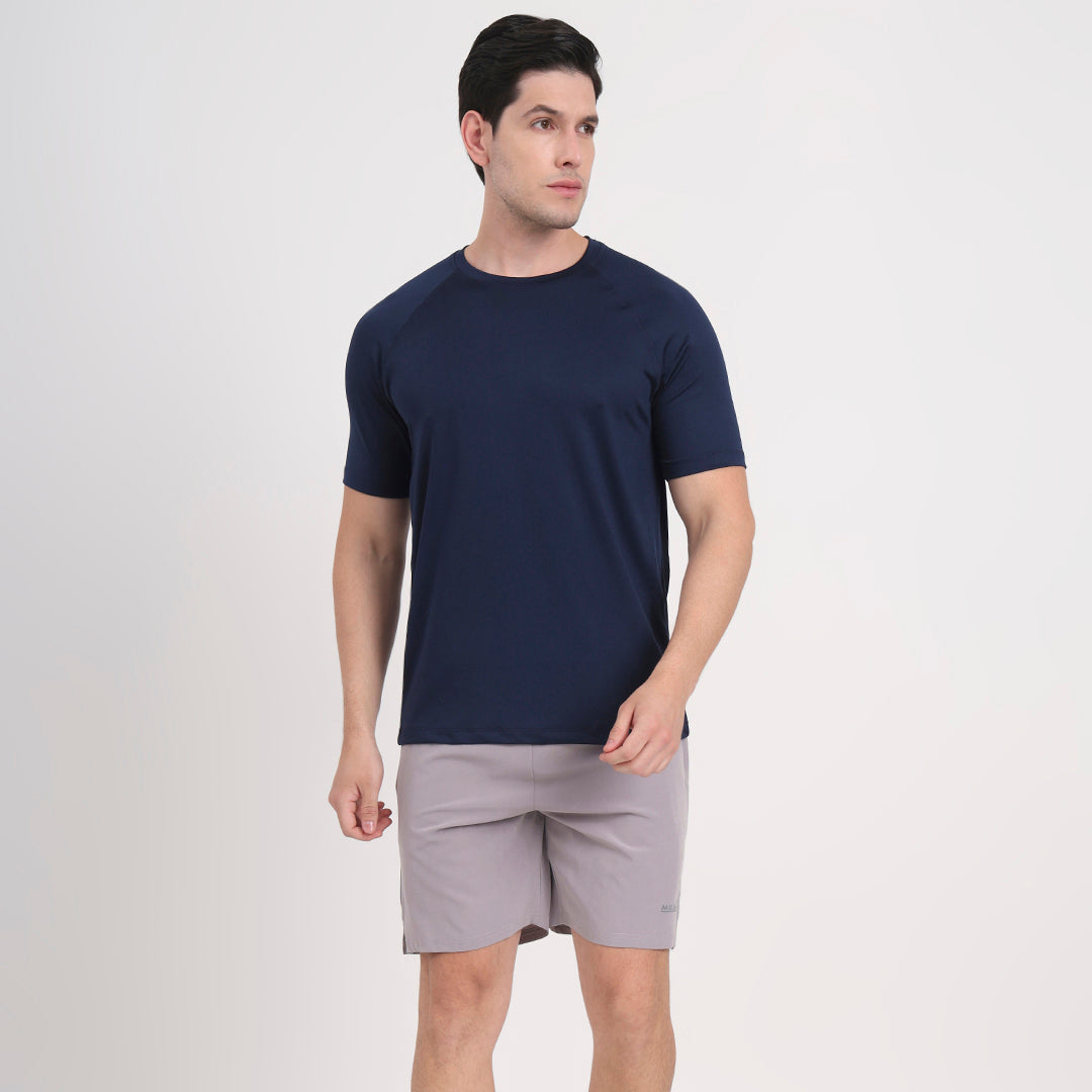 Men’s navy blue t-shirt paired with gray shorts, casual summer outfit on white background